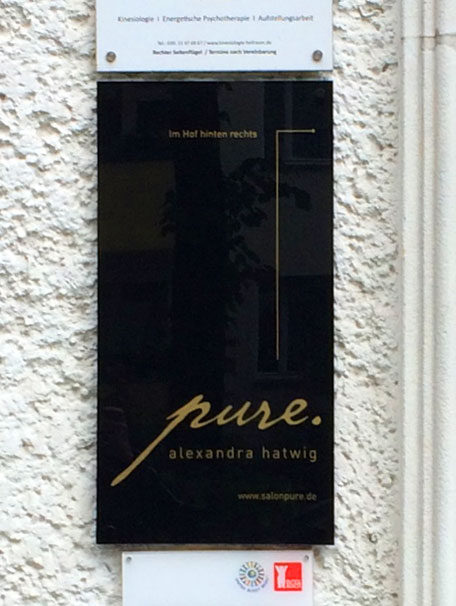 Schild an der Toreinfahrt zum Friseursalon pure
